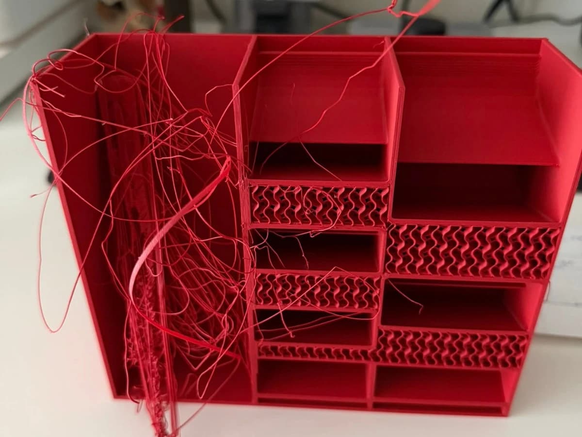 Mislykket 3D-utskrift i rødt: løse filamenttråder og feil i de innvendige nivåene